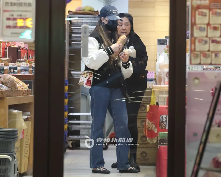 歐陽娣娣（左）手拿紅薏仁銀耳露和麵包去結帳。特勤中心攝