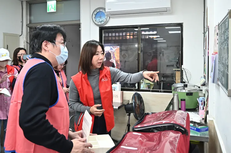 永齡基金會執行長郭曉玲聆聽立心基金會陳穎叡顧問說明，瞭解廚房每天出餐的數量及特殊需求。永齡基金會提供