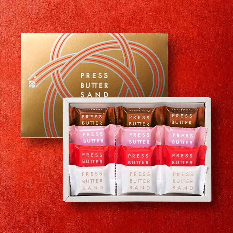 PRESS BUTTER SAND 水引結心意新春禮盒內含白桃焦糖奶油夾心餅乾、栗子焦糖奶油夾心餅乾、草莓焦糖奶油夾心餅乾，以及經典原味焦糖奶油夾心餅乾，共12  入，每盒售價 1180 元，現正預購中。業者提供
