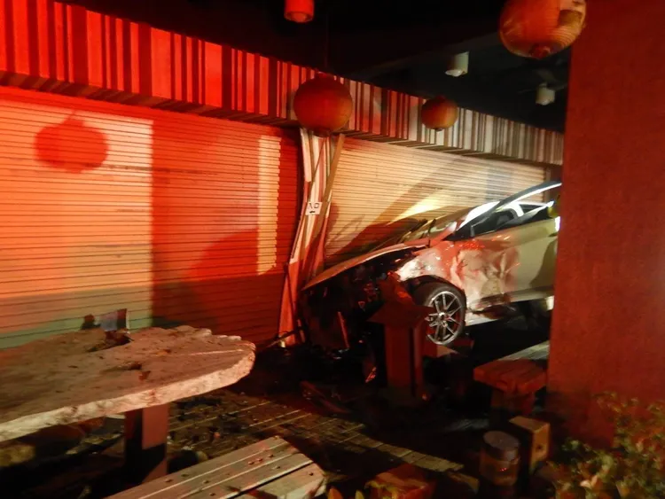 林男轎車衝入路旁火雞肉飯店家，鐵門及店內桌椅遭撞壞。民眾提供