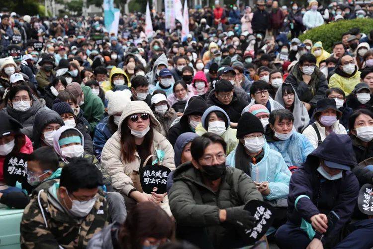 上萬名民眾黨支持者11日集結北市自由廣場，有不少人手持「綠色威權，司法不公」小扇子。記者 李俊毅攝