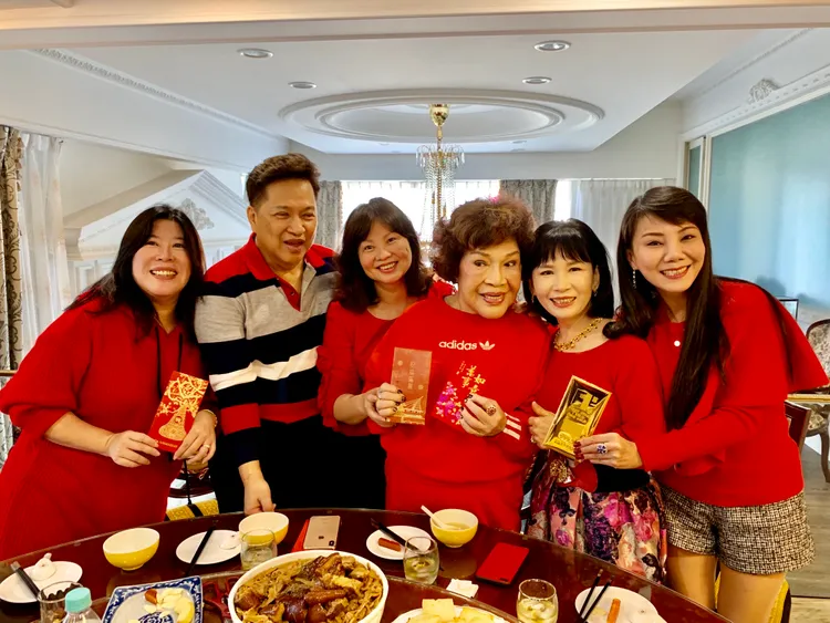 阿姑和李朝永提前發紅包給來拜年的乾女兒們。李朝永提供