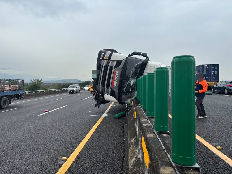 大貨車爆胎側翻，撞上分隔島，一整排防眩桿都被掃飛。警方提供