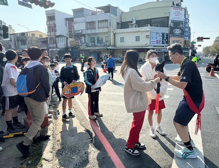 立德國中師生為高雄富邦馬拉松跑者傳遞茶水，給予歡呼。教育局提供