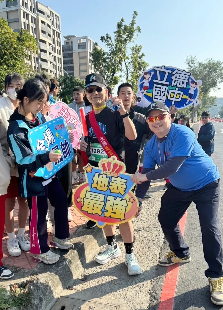 立德國中師生為高雄富邦馬拉松跑者傳遞茶水，給予歡呼。教育局提供