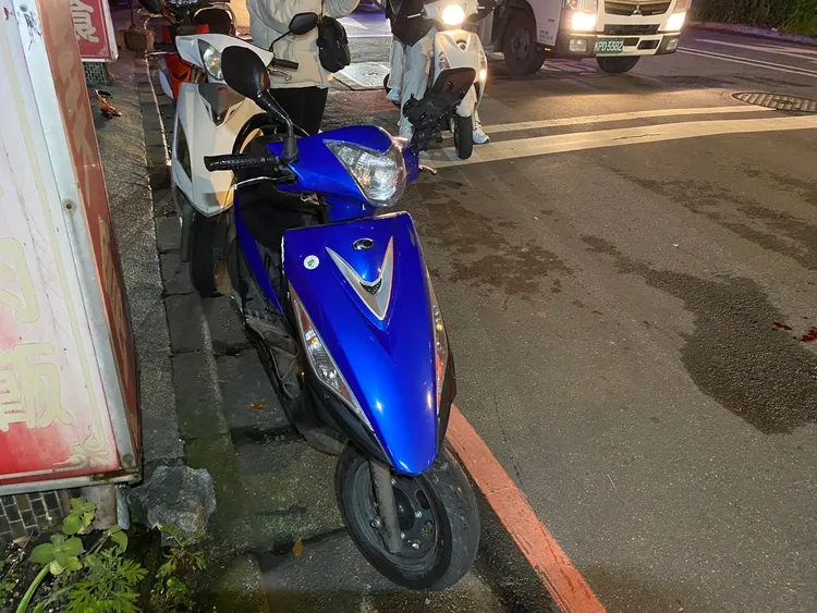 藍色機車被撞到車尾，失去重心摔車，車身也多處毀損。翻攝畫面