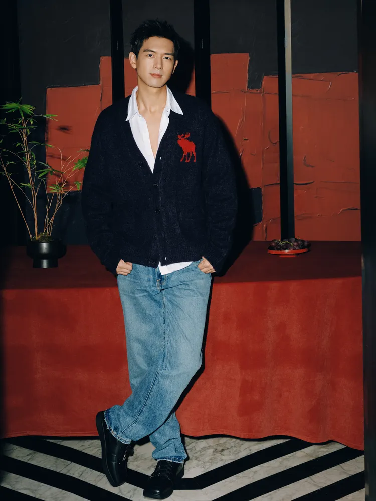 李現穿著深藍色針織衫、白襯衫搭配牛仔褲。品牌提供