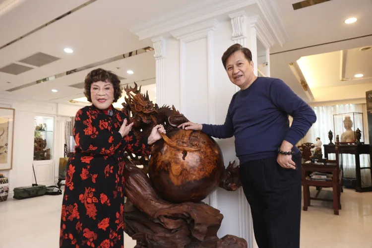 阿姑（左）和李朝永與收藏品「飛龍在天」木雕合影，該作品也是阿姑最近買的藝術品。彭欣偉攝