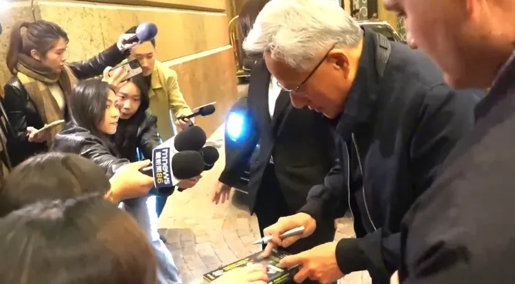 粉絲拿著「黃仁勳傳」要求黃仁勳幫忙簽名。特勤中心攝