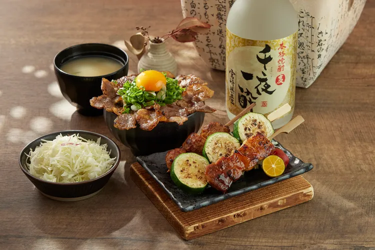 「味噌豚串燒盛合」將厚切豚五花刷上微辣香甜的特製味噌醬，透過直火高溫燒烤，肉汁與味噌的香氣完美交織。搭配清新的櫛瓜和柔嫩的雞肉丸子，組成一道經典串燒盛合。業者提供