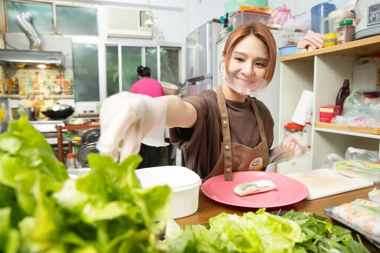 郭靜細心地請教葉阿姨包春捲的細節，因米線包太多春捲快炸開，被廚房阿姨打趣地吐槽：「包太多了啦！」天主教博愛基金會提供