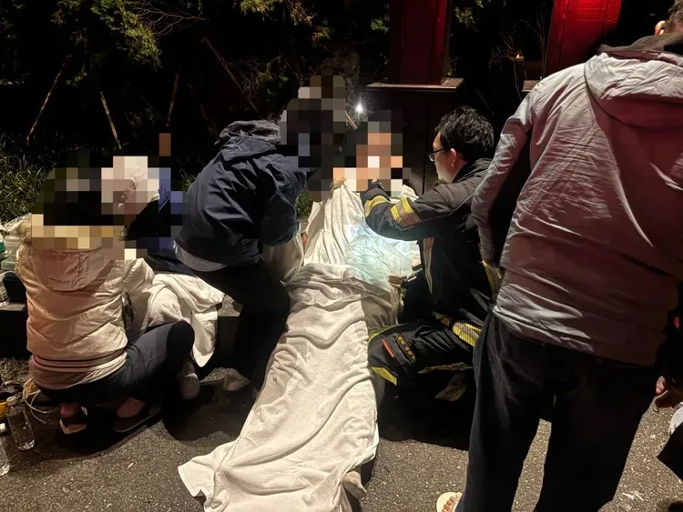 救護人員將用棉被包裹逃出火場的員工緊急給氧並送醫。民眾提供