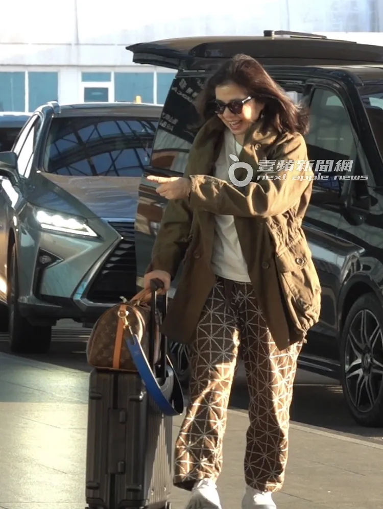 鍾楚紅將LV包掛在登機箱上，有說有笑走進機場出境大廳。特勤中心攝