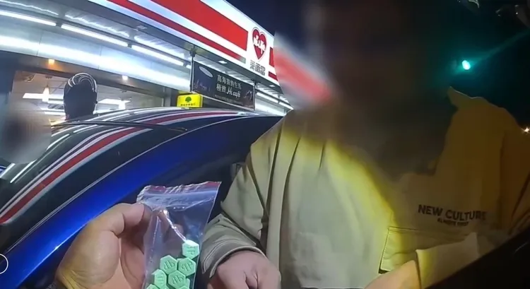 袁嫌包包內收出毒品哈密瓜錠，面對警員質問還矢口否認。翻攝畫面