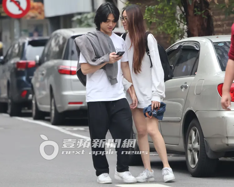 Dora（右）在路邊牽著男生，緊貼講悄悄話。特勤中心攝