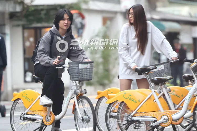 Dora（右）與男生把共享單車牽出準備騎乘。特勤中心攝