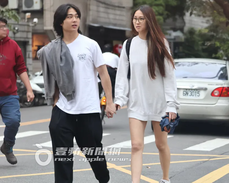 長髮男帥氣插口袋，牽著Dora過馬路。特勤中心攝