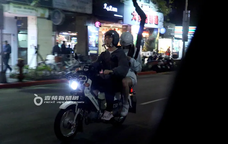 Dora坐在機車後座玩手機。特勤中心攝