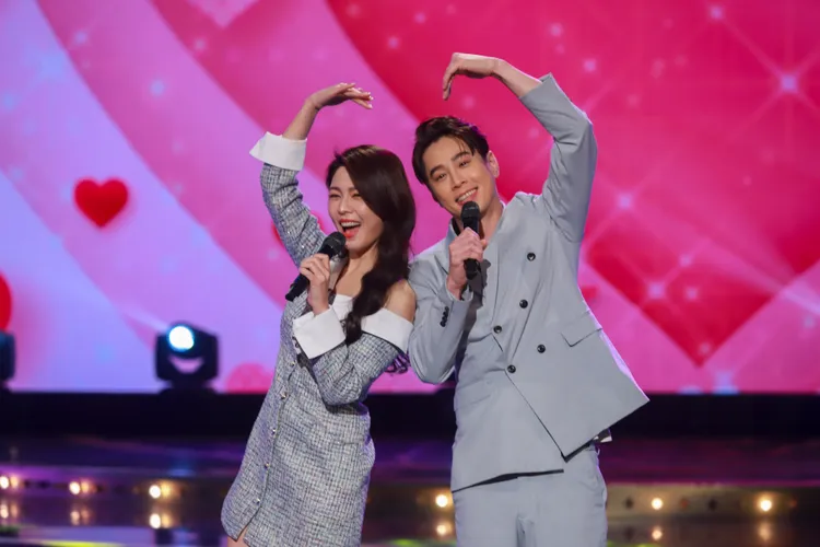 白家綺（左）、吳東諺手比愛心秀恩愛。民視提供