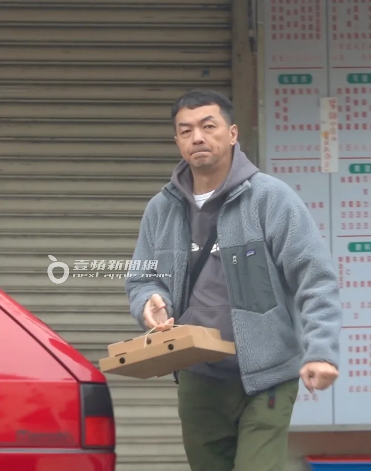 邱彥翔拿完一大一小披薩，往車上前進，許久不見有些發福。特勤中心攝