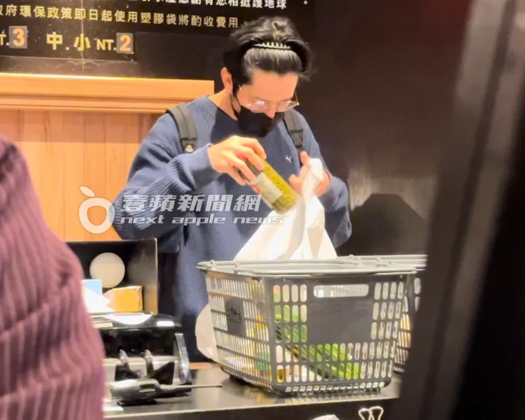 胡宇威將採買的食材放進購物袋。特勤中心攝