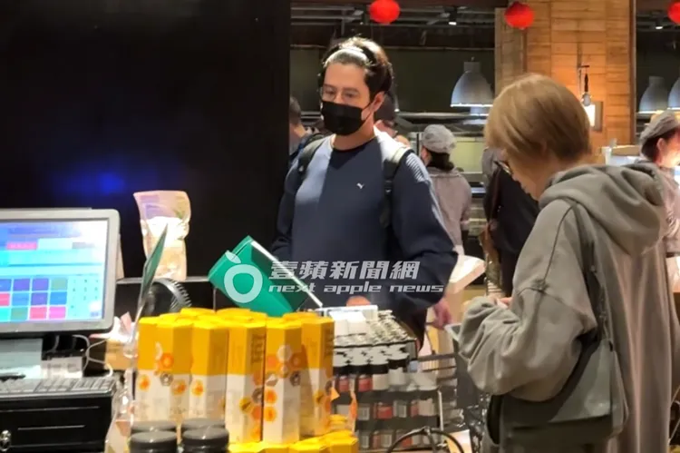 胡宇威提著一大籃食材，到櫃檯跟民眾一起排隊結帳。特勤中心攝