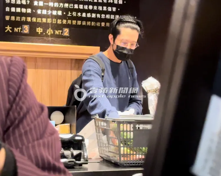 胡宇威在櫃檯結帳，整理採買的食材。特勤中心攝