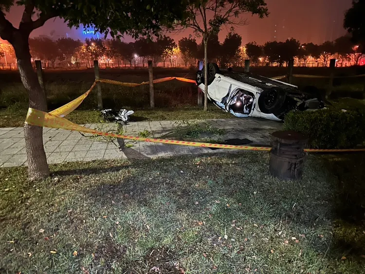 賓士轎車自撞路緣後衝進人行道翻覆。民眾提供