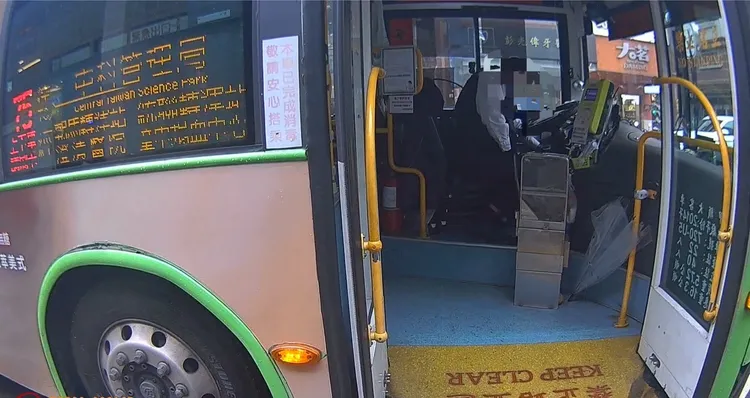 陳姓公車司機坐在駕駛座臉色蒼白、神情痛苦，並緊捂胸口。民眾提供