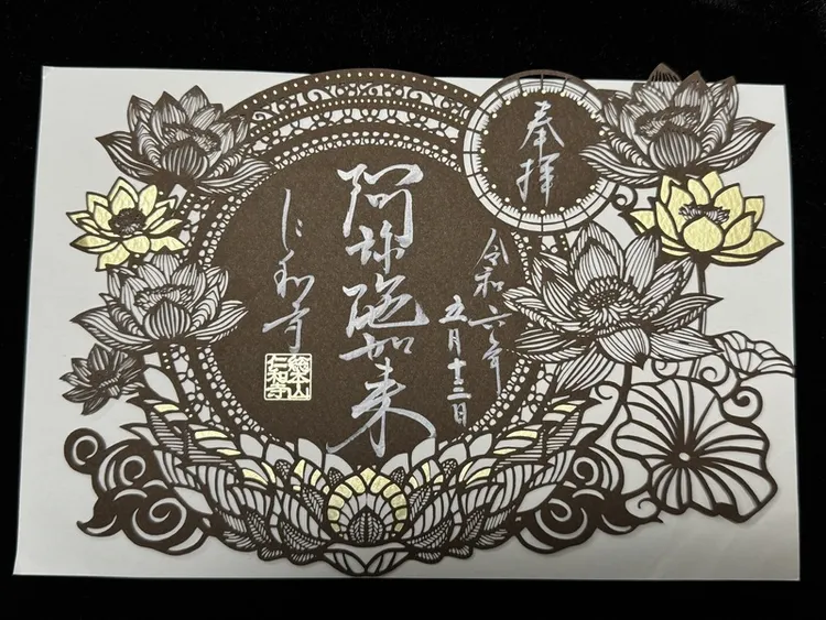 御朱印是一種參拜寺院神社後求得白紙，上面以毛筆書寫寺院神社名稱、參拜日期、蓋有朱印，是人與神佛結緣的證明。現在御朱印的設計多元，有的是結合剪紙藝術，寺社在特定期間推出特殊御朱印。圖為京都仁和寺御朱印，中央寫著祀奉的主神阿彌陀如來。 中央社