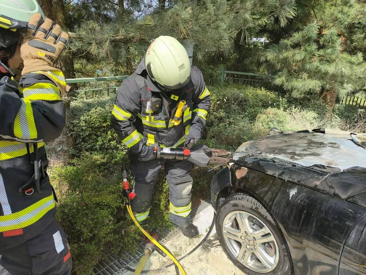 消防人員撬開賓士引擎蓋灌水，以防火勢復燃。南投縣消防局提供