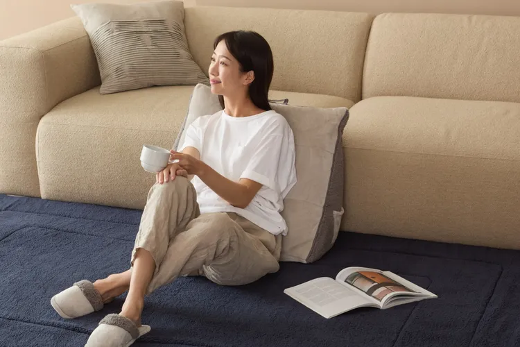 「WARM TOUCH石墨烯法蘭絨絎縫三角靠墊-灰藍」適合有睡前閱讀、追劇或席地使用電腦習慣的消費者，獨家波浪枕三角造型，不只溫暖搭更貼合腰背曲線。業者提供