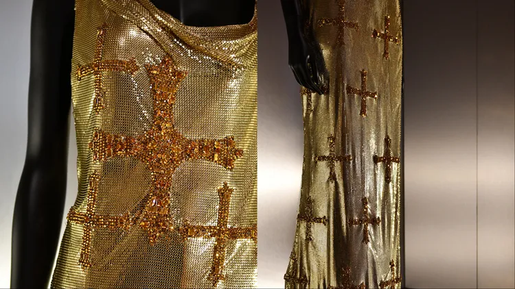 金屬網紗晚禮服佈滿拜占庭十字圖案刺繡，並以托帕石色調的施華洛世奇水晶點綴。品牌提供