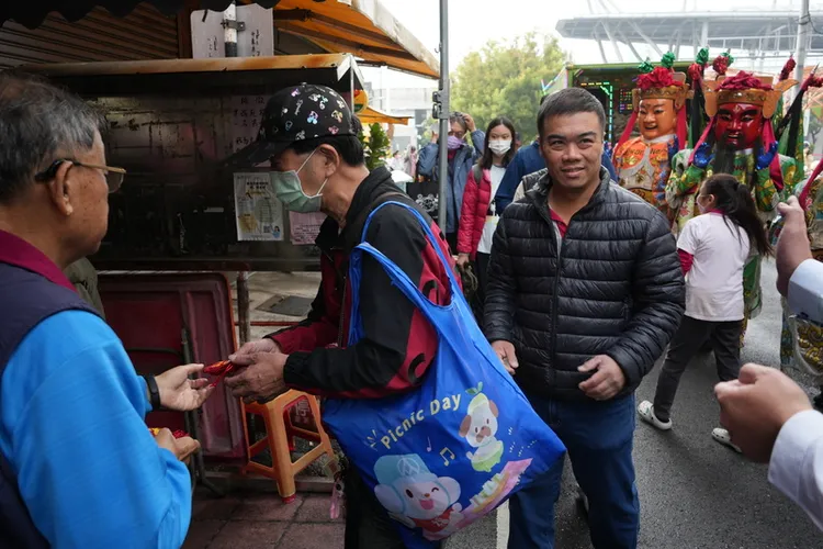 屏東市都城隍廟1日依慣例發錢母。圖為民眾排隊領取。中央社