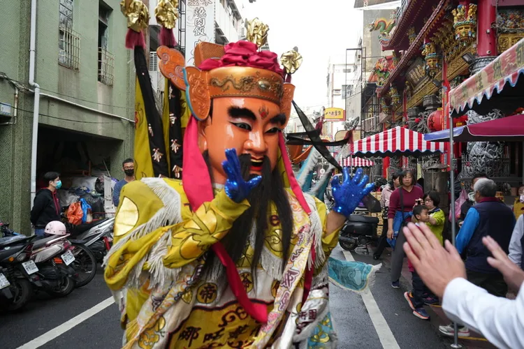 屏東都城隍廟1日發放錢母，請來各式神尊與現場民眾擊掌、互動，現場喜氣洋洋。中央社