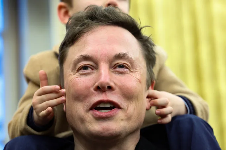 馬斯克兒子戳他耳朵，打斷他的談話。路透社