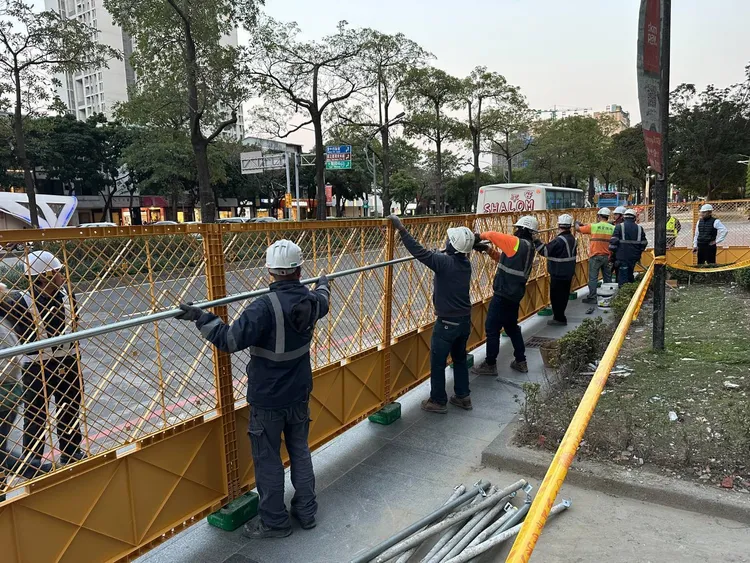 新光三越架設地面層安全圍籬，後續進行外牆附掛物吊掛及防護作業。中市府提供