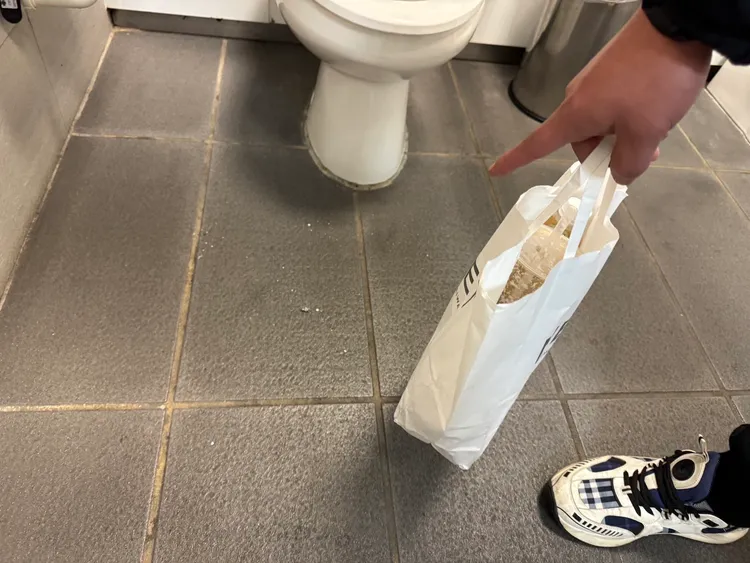 翁男腳下穿的也是Burberry名牌運動鞋，手指地板被他彈落的煙灰。民眾提供