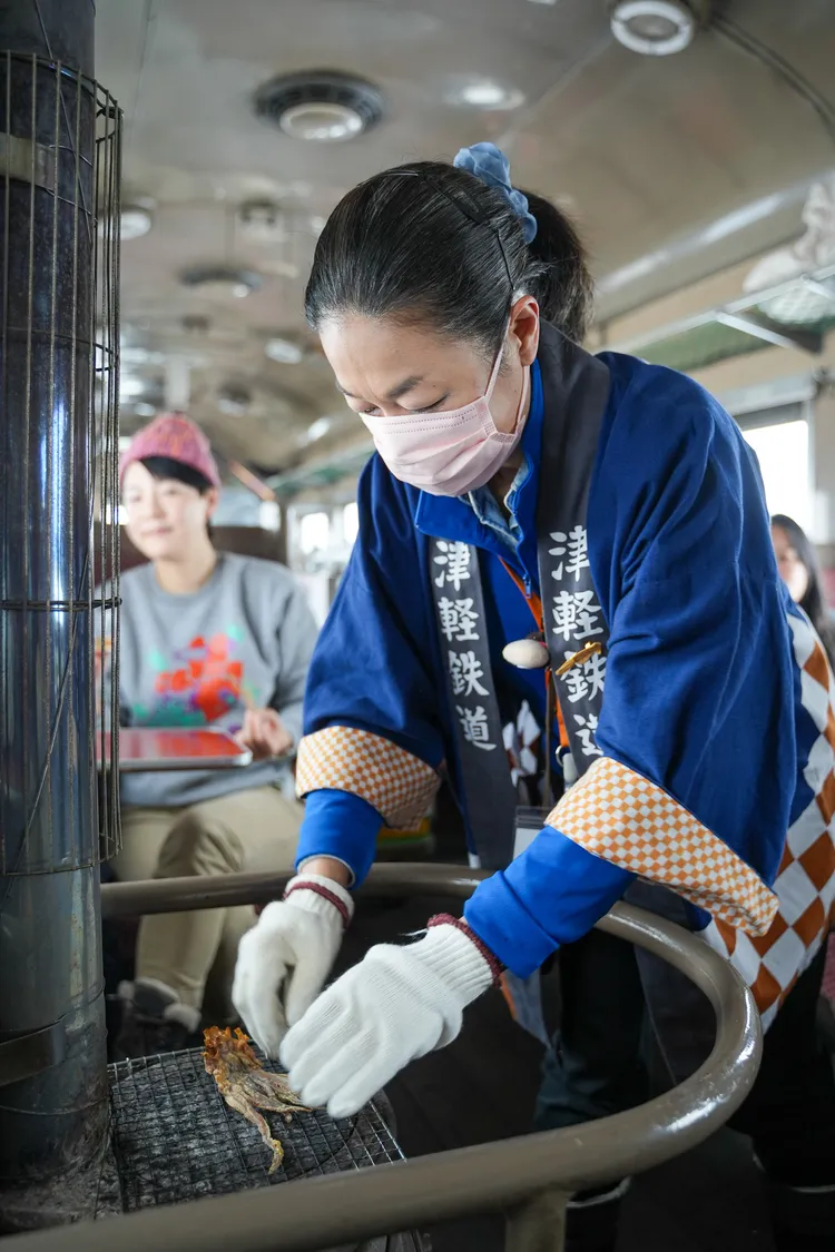 服務人員協助遊客烤魷魚。田欣雲攝影