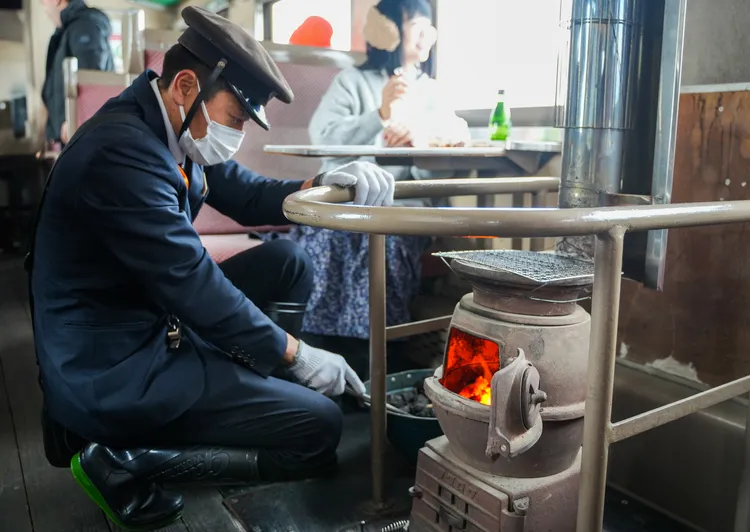 列車服務員為暖爐添炭。田欣雲攝影