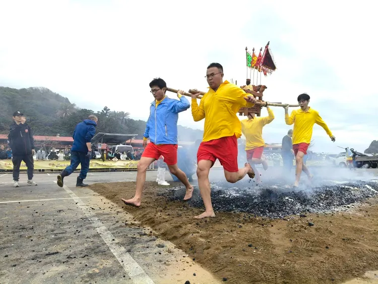 宮廟人員扛起神轎赤腳踏過撒上鹽與米的火堆，象徵淨化身上的晦氣。公所提供