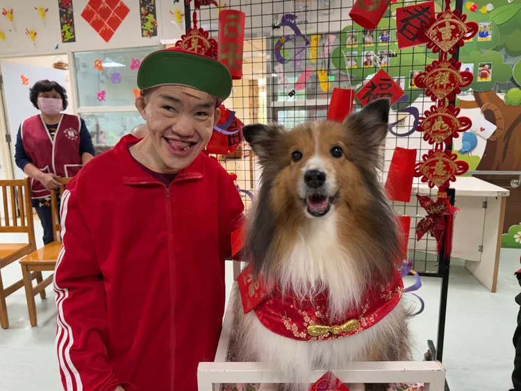 憨兒和狗醫生精心搭配大紅討喜裝扮迎接春節。社會局提供