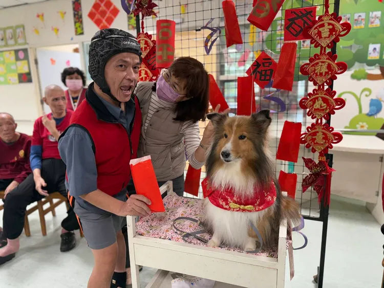 憨兒開心推著狗醫生乘坐的福氣專車抽紅包。社會局提供