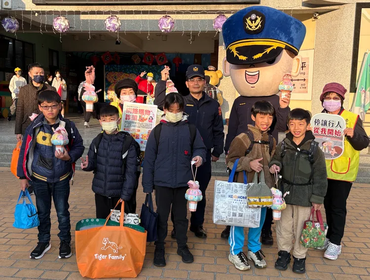 台中第三警分局副分局長鄭又銘提著小燈籠祝福學童前程似錦，並與宣導團在和平國小護童，發送菜瓜布跟口罩，。警方提供