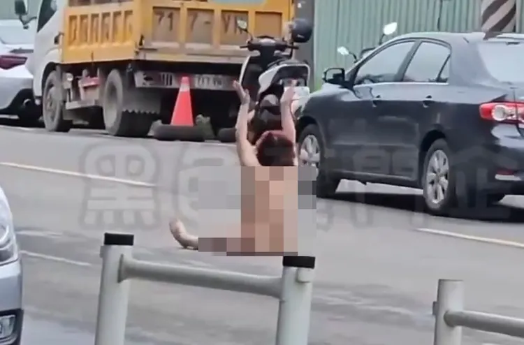 裸女坐在地上向往來車輛招手。翻攝黑色豪門企業