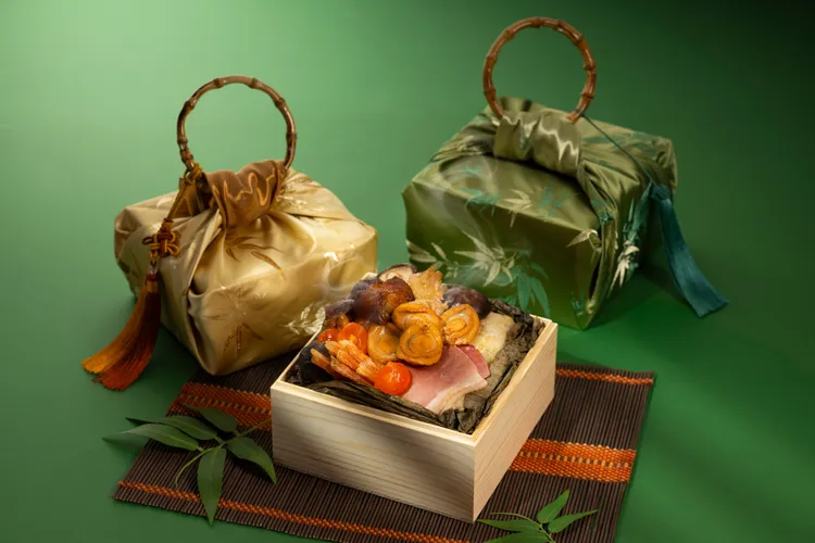 台北遠東香格里拉「霸王級乾隆一品粽」外包布巾提供「金緞」與「竹影」兩款設計，搭配精緻竹節手柄與流蘇點綴，典雅貴氣，布巾隨機出貨，不挑色、不挑款。台北遠東香格里拉提供