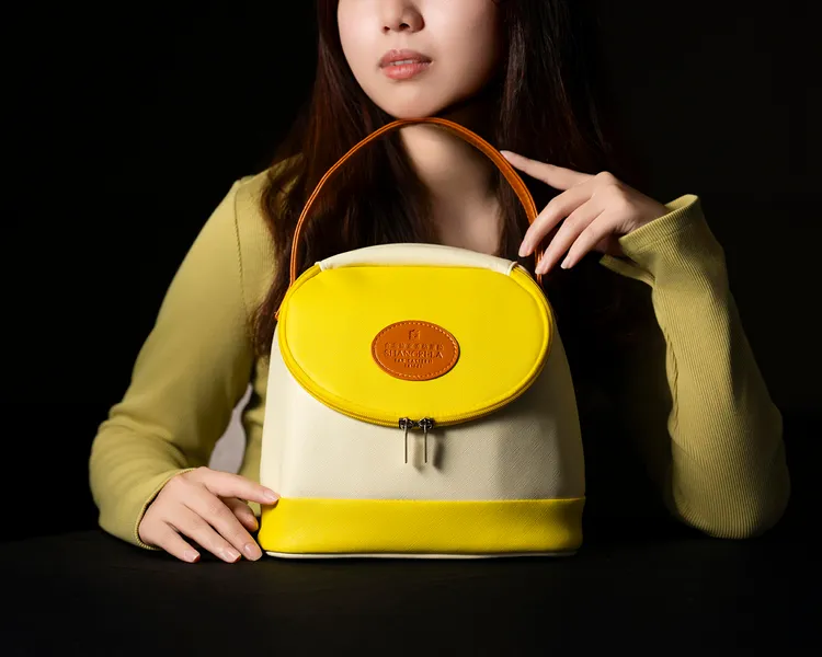 台北遠東香格里拉「粽享食尚風潮禮袋」，黃白拼色圓弧包明亮活潑，適合輕旅行與日常穿搭，內含五款經典風味粽，每袋1488元。台北遠東香格里拉提供