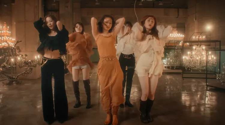 隊長金采源（中）身穿Chloé有機絲質薄紗長洋裝，搭配Iconic復古金手寫logo腰鍊。翻攝HYBE LABELS Youtube