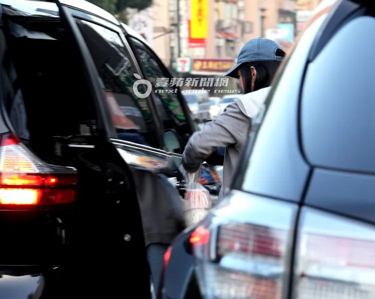 蔣黎麗上車前將3大袋打包食物交給富商。特勤中心攝
