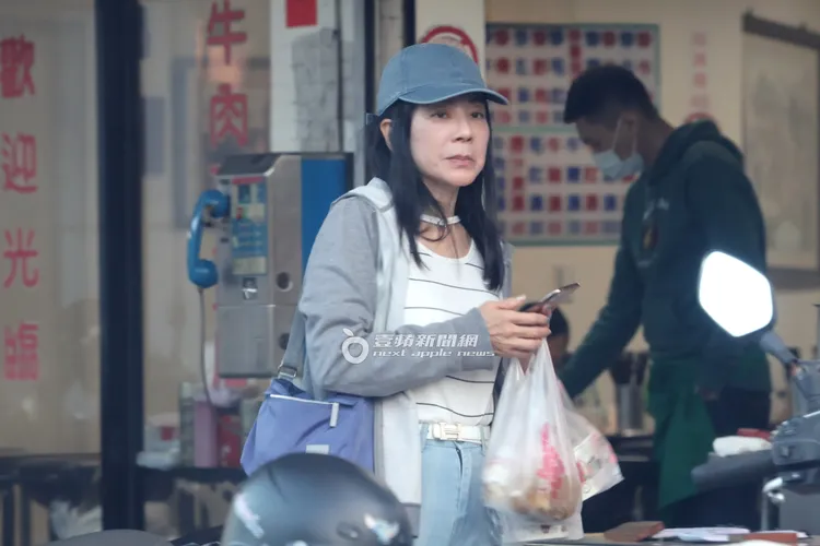 蔣黎麗提著餐點在店外等候富商埋單。特勤中心攝